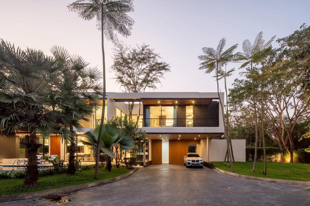 a house with a car parked in the driveway at Cicada Estate in Ban Mae Pu Kha