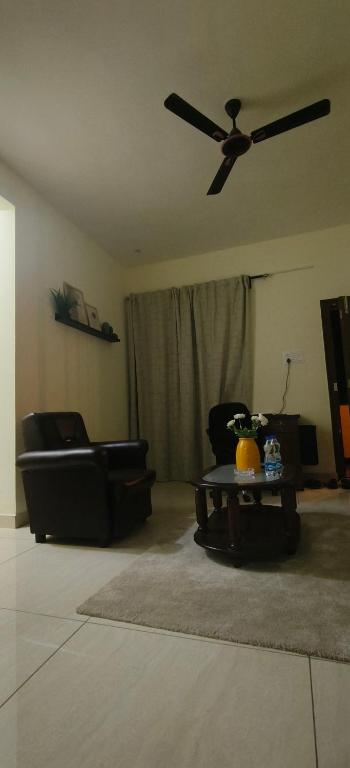 a living room with a ceiling fan and a table at Hangang M building in Avati