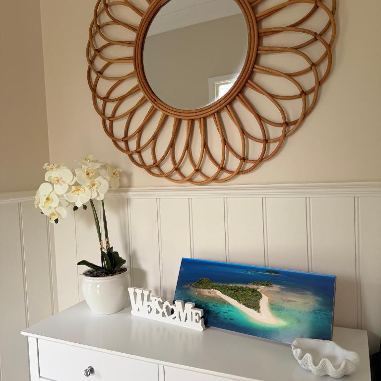 a mirror on a wall above a white table at Quintessential Kewarra in Kewarra Beach
