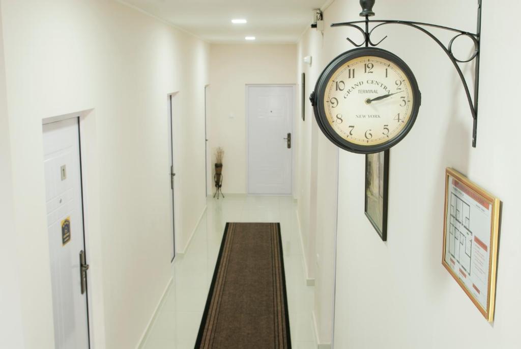 a clock hanging on a wall in a hallway at Guest House Centar lux in Zrenjanin