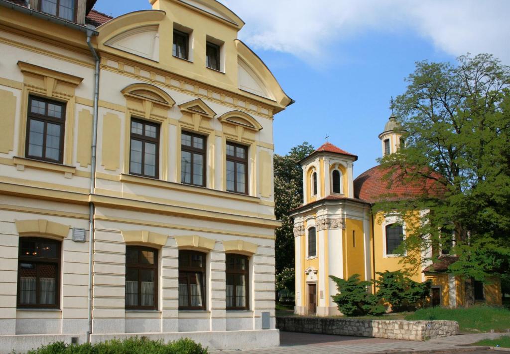 un ancien bâtiment avec une tourelle à côté d'un autre bâtiment dans l'établissement Hotel Casanova, à Duchcov