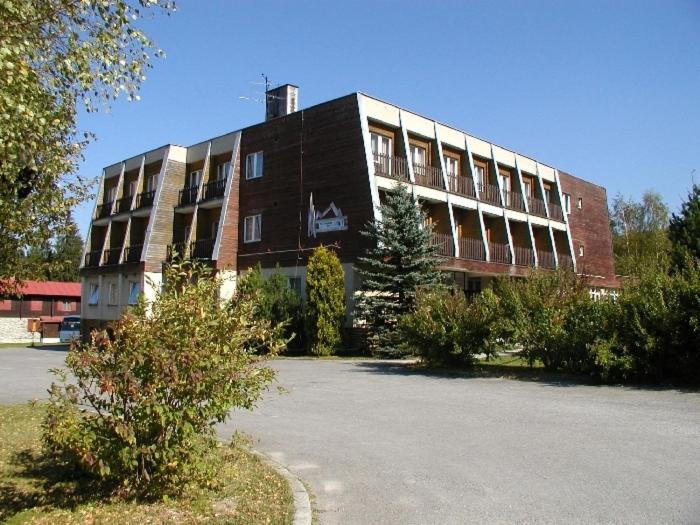 a large brick building in front of a parking lot at Hotel Tatrawest in Zuberec