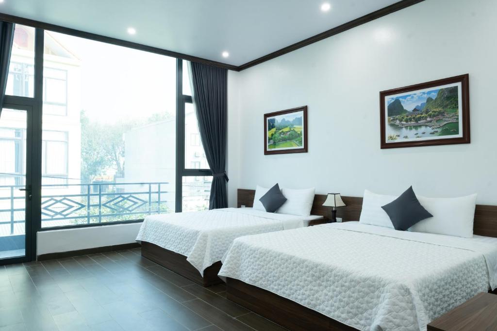 a bedroom with two beds and a large window at Tamcoc Cloud Homestay in Ninh Binh