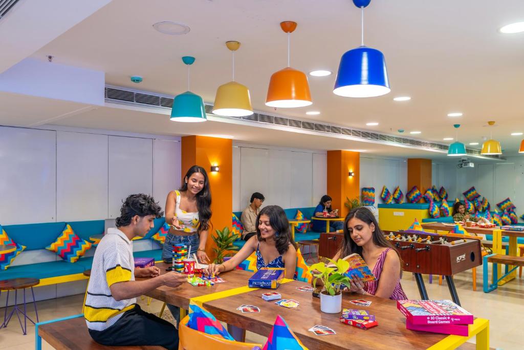 a group of people sitting at a table at goSTOPS Bengaluru, Jayanagar - Private Rooms & Dorms in Bangalore
