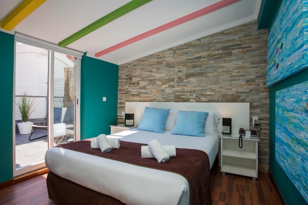a bedroom with a large bed with blue pillows at Olympia Consul del Mar in Valencia