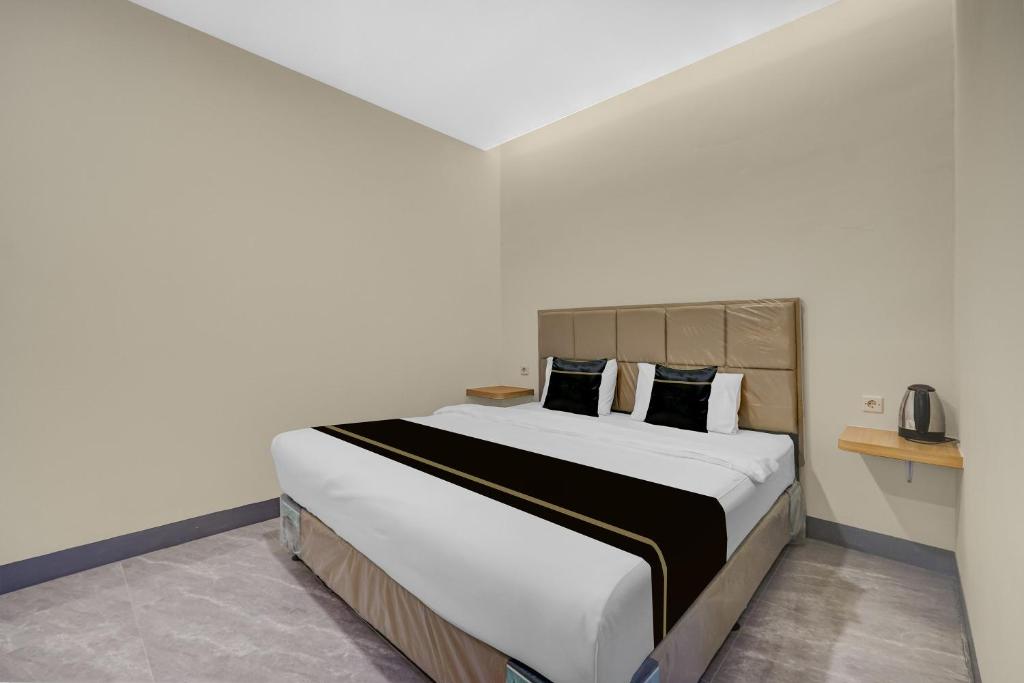 a bedroom with a large bed with white sheets and pillows at Hotel O Ciapus Bogor in Bogor