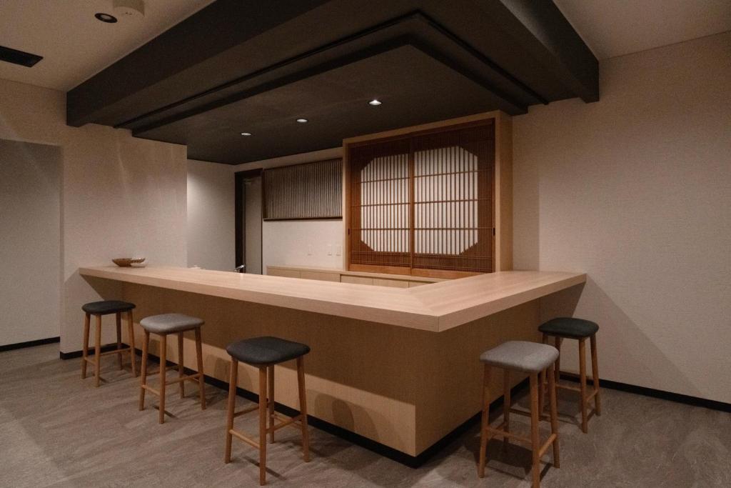 a kitchen with a bar with stools around it at Boutique Stay Kanazawa Oost Knoll in Kanazawa