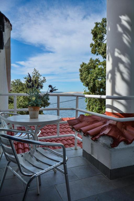 a table and chairs on a balcony with the view of the ocean at Apartments Miki in Donja Klada