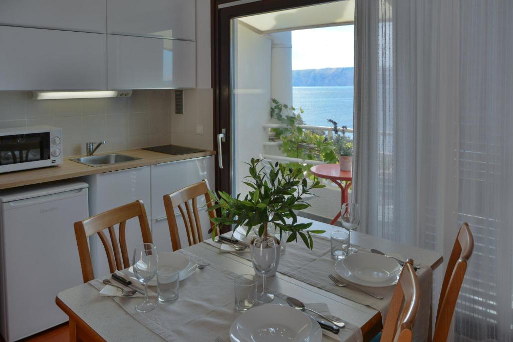 a kitchen with a dining table with a view of the ocean at Apartments Miki in Donja Klada