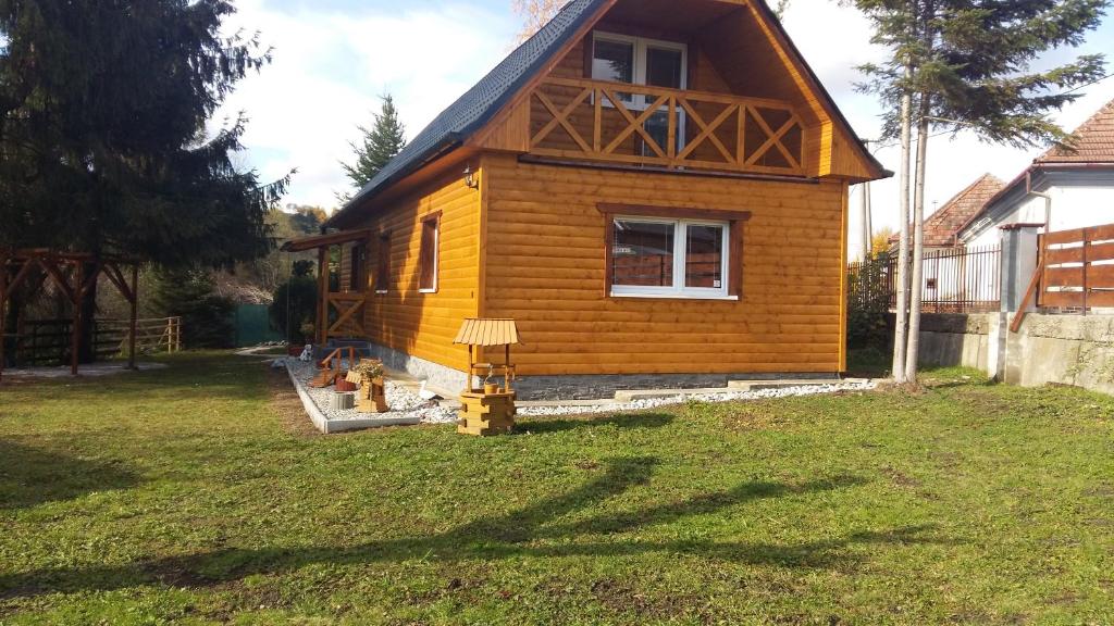 a small yellow house in a yard at Liptovská Chata pri potoku in Liptovský Mikuláš