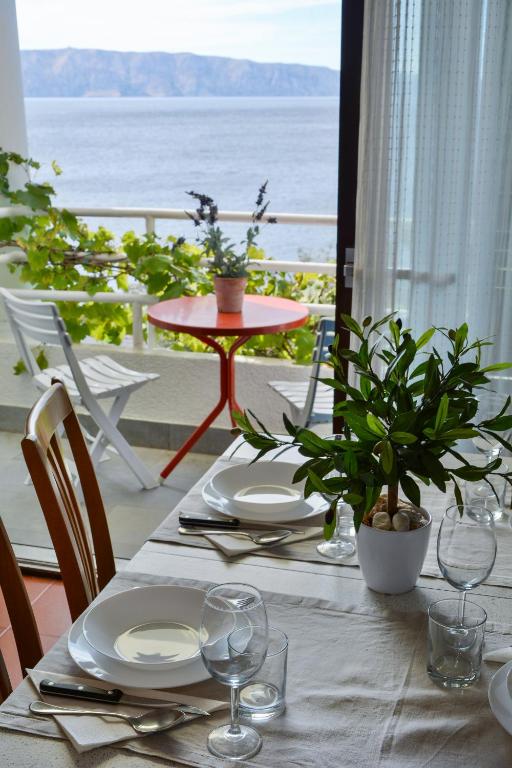 a table with plates and glasses on top of a balcony at Apartments Miki in Donja Klada