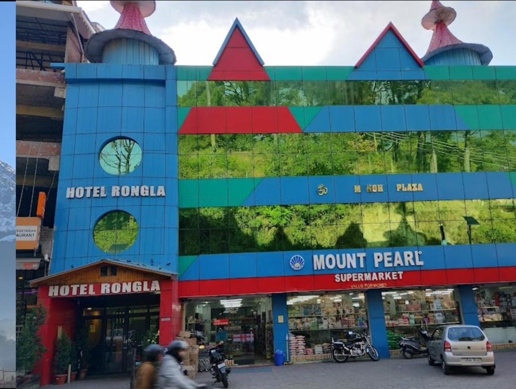 a building with people walking in front of it at Hotel Rongla in Pālampur