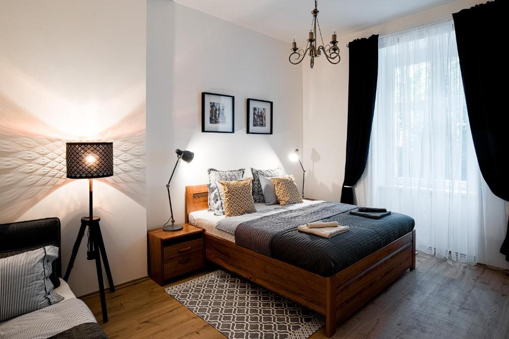 a bedroom with a bed and a lamp at Apartment Gesse Březinova in Prague