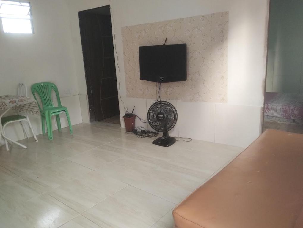 a living room with a fan and a tv on a wall at 3-bedroom house on Cabuçu beach in Saubara