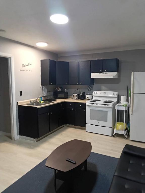 a kitchen with black cabinets and a white stove at Cosy single-level home with laundry and parking in Huntington