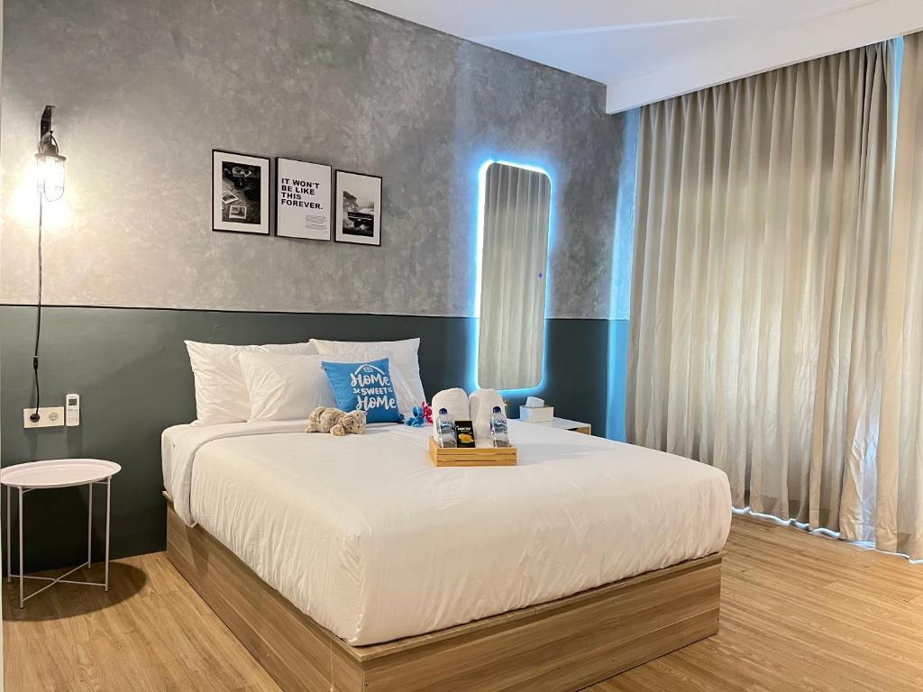 a bedroom with a large white bed with a table at Turuku in Bandung