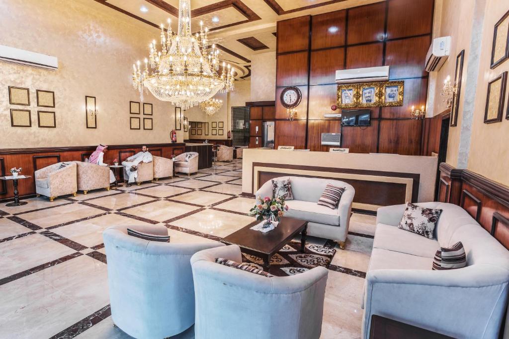 a lobby with a chandelier and a table and chairs at Manazel Al Sofara in Yanbu