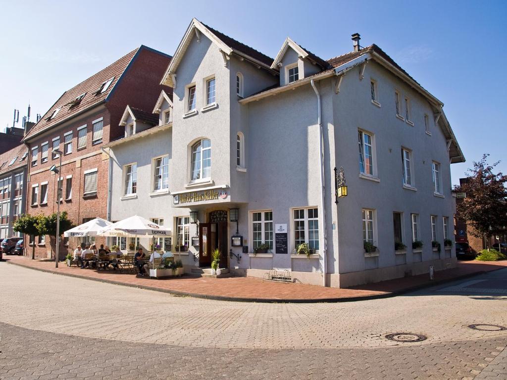 - un grand bâtiment blanc dans une rue de la ville dans l'établissement Hotel-Restaurant Haus Keller, à Laggenbeck