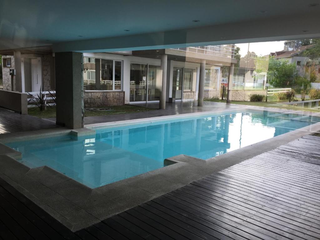 a large blue swimming pool in a building at Solo Pinamar in Pinamar