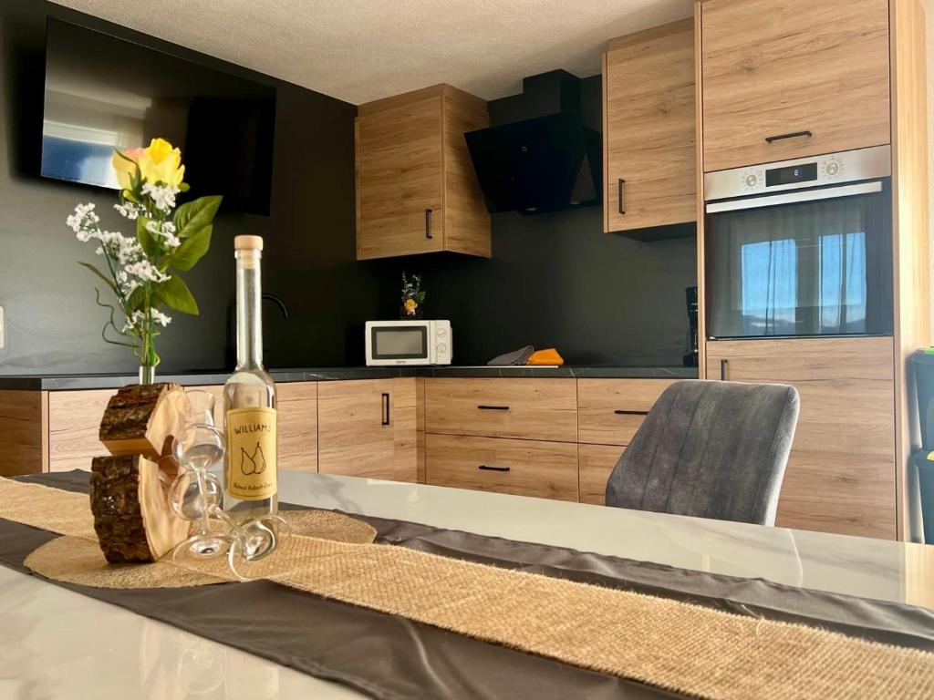 a bottle of wine sitting on a table in a kitchen at Apart Alpenflair 74 in Fliess