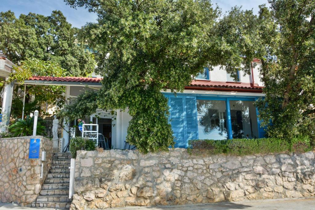 a blue house with a stone wall at Apartments Miki in Donja Klada