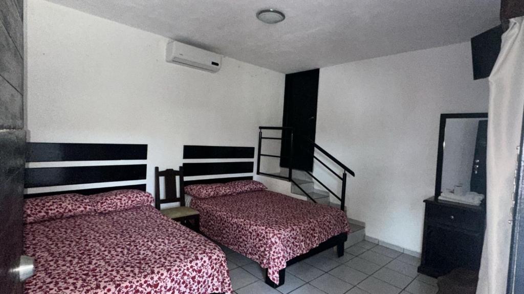 a bedroom with two beds and a mirror at Rincon el Mirador in Tamasopo