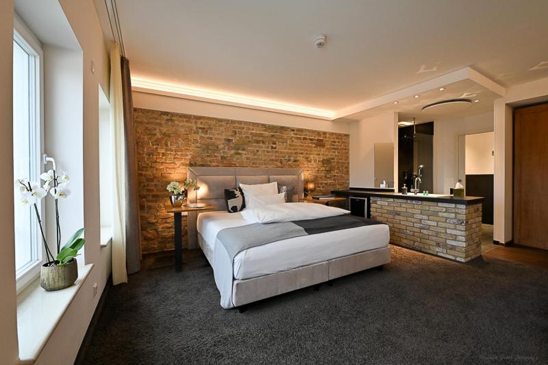 a bedroom with a bed and a brick wall at Höll am Main in Rüsselsheim