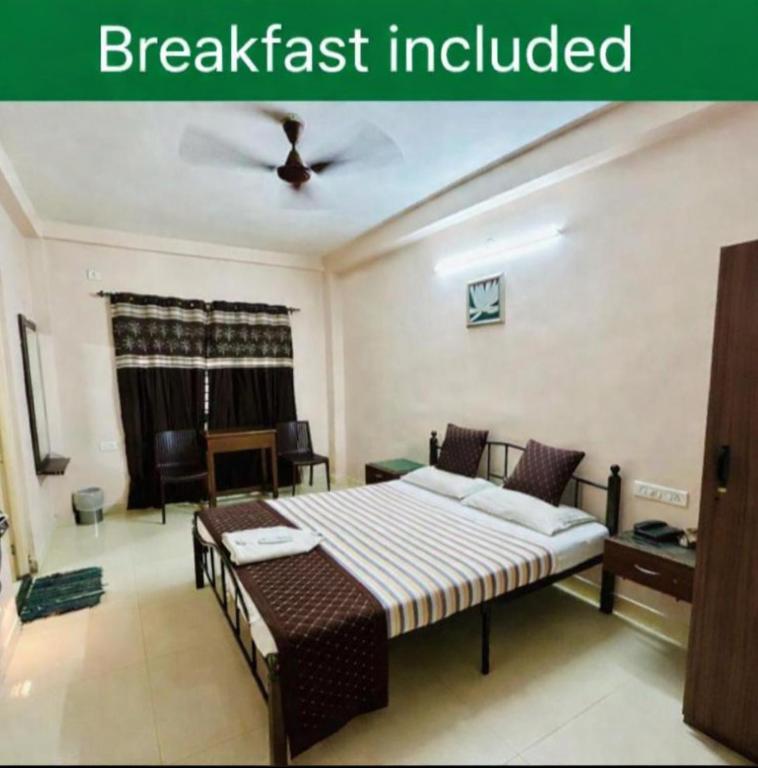 a bedroom with a bed and a ceiling fan at Hotel Jothi in Coimbatore