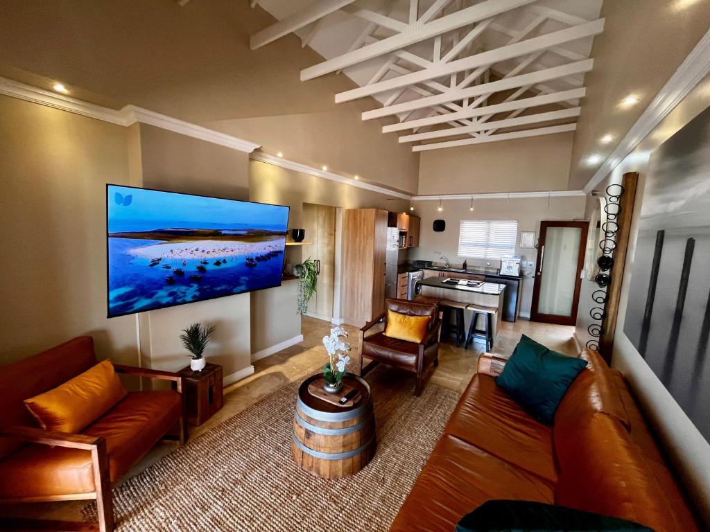 a living room with a large flat screen tv on the wall at Hill Fore! in Langebaan