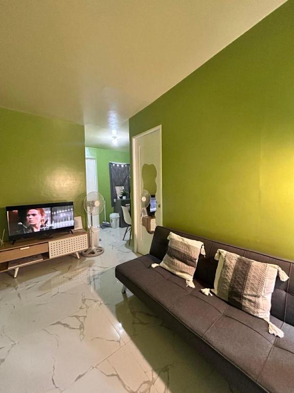 a living room with a couch and a flat screen tv at Casa Uno Leyte in Palo
