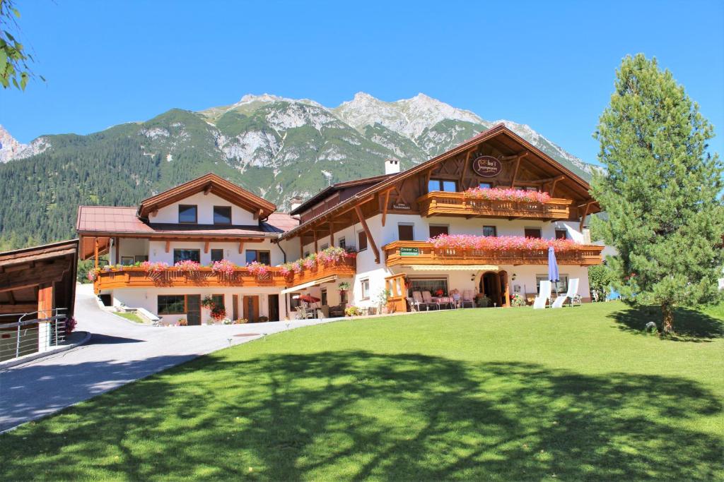 a large house with mountains in the background at Ivos Sonnenpension in Leutasch