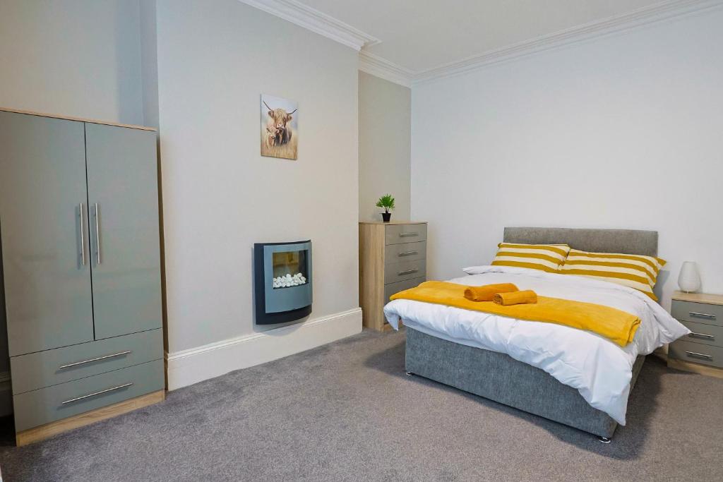 a bedroom with a bed and a cabinet and a tv at Elevate suites Darlington in Darlington