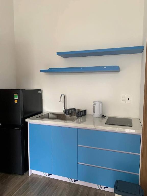 a blue kitchen with a sink and a refrigerator at Magallanes Escape in Manila