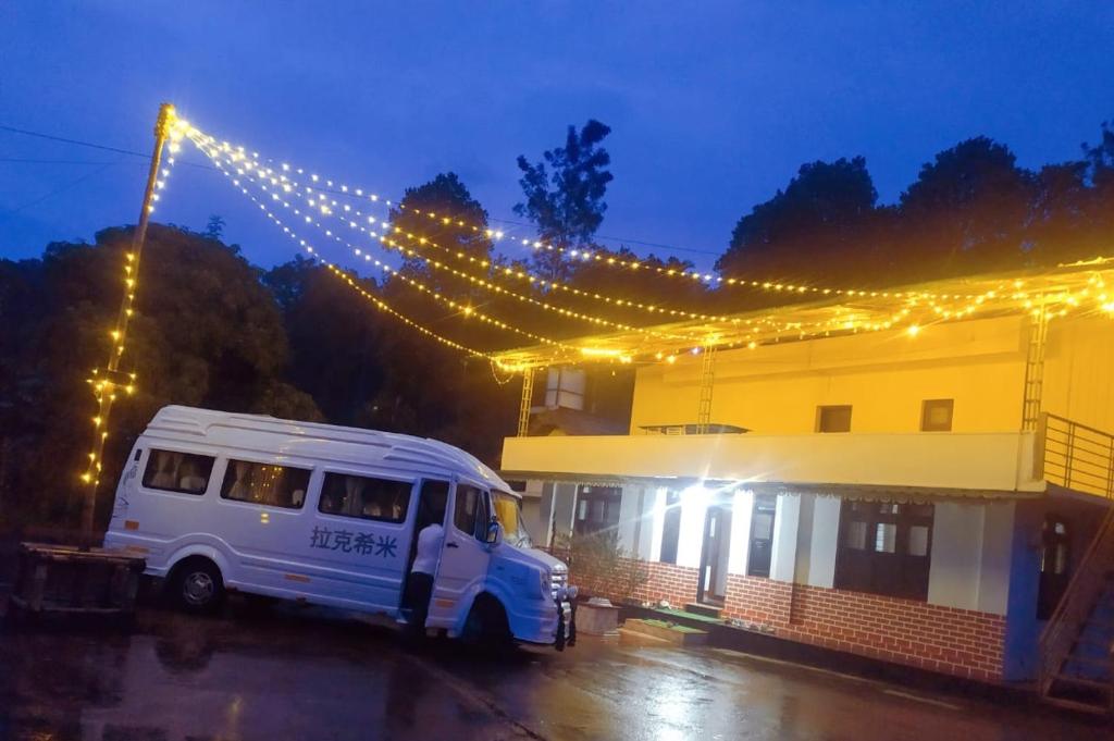 a white van parked in front of a building with lights at Coffee land in Kaniyāmbetta