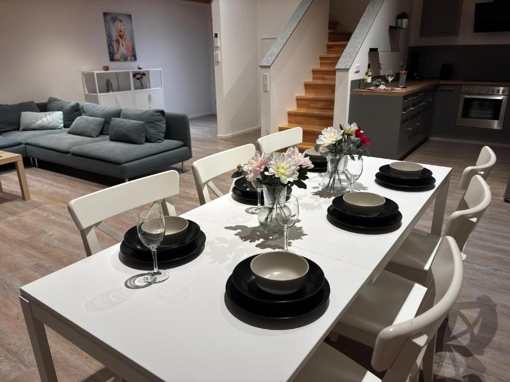 a white dining room table with black hats on it at StorchenNest Pfeifers OdenwaldNest in Rimbach