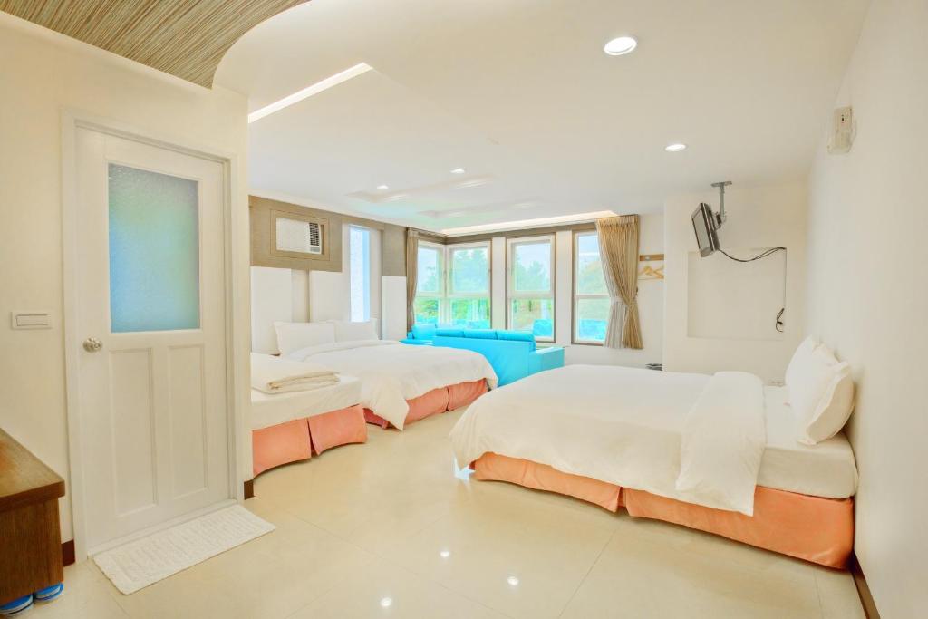 a white room with two beds and a window at Natural Residence B&amp;B in Tai&#39;an