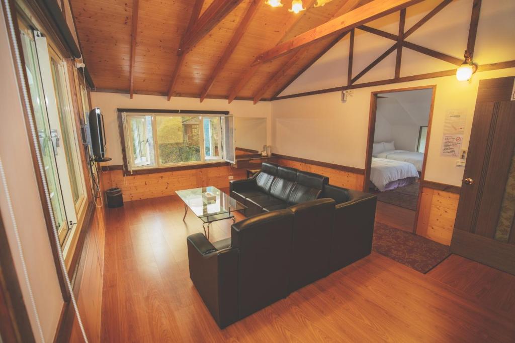 a living room with a couch and a table and a bed at Natural Residence B&amp;B in Tai&#39;an