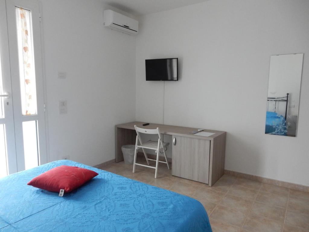 1 dormitorio con cama y escritorio con almohada roja en C'era Una Volta, en Bastia Umbra