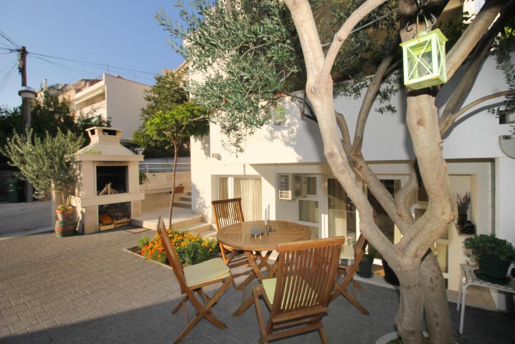 a table and chairs sitting next to a tree at House Skrabic in Makarska