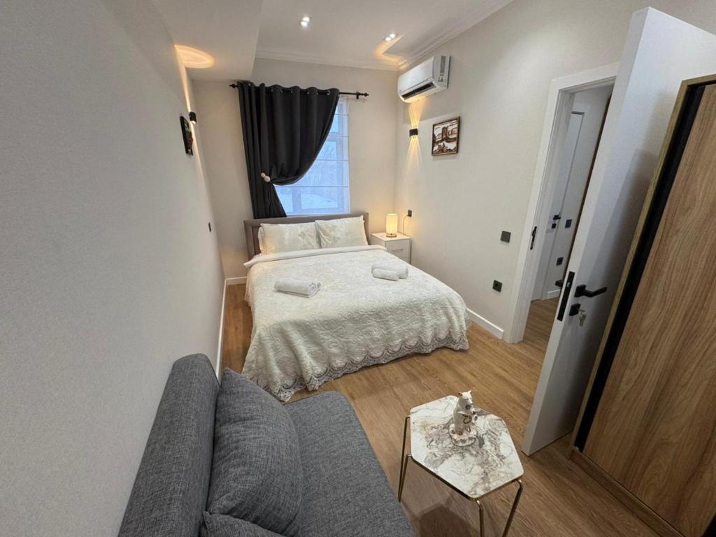 a small bedroom with a bed and a couch at Maiden Tower Prestige in Baku