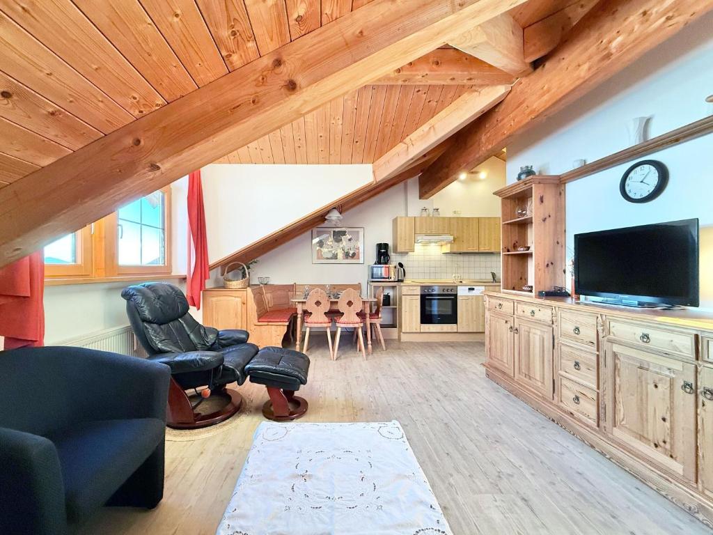 a living room with a couch and a television and a table at Sonnenhof Seeg 19 in Seeg