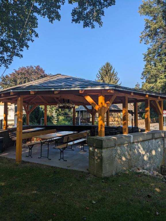 a pavilion with tables and benches in a park at Ferienwohnung am Park in Greiz