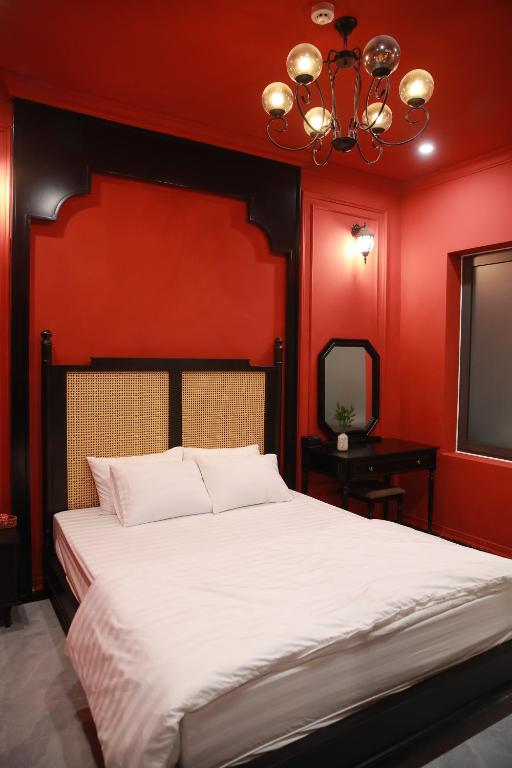 a bedroom with a large bed with red walls at Gấu Hotel Cầu Giấy in Hanoi