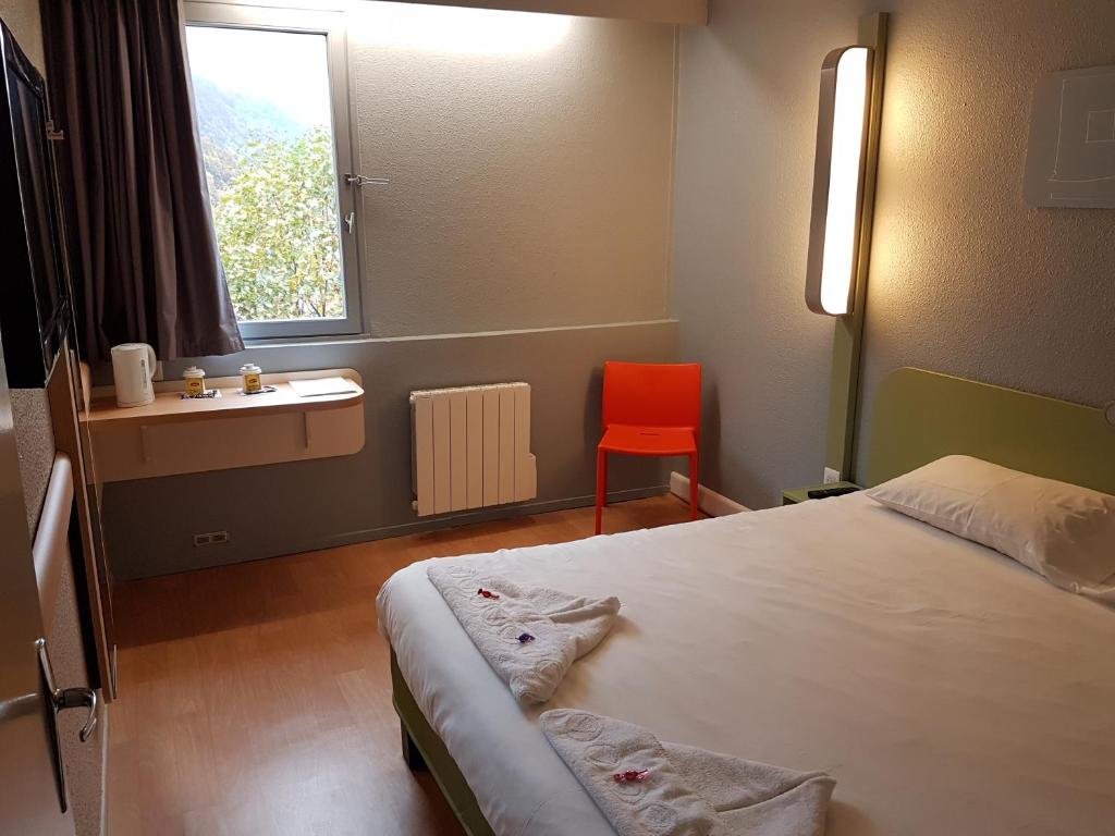 een slaapkamer met een bed, een wastafel en een raam bij Hotel Inn Design Moutiers in Moutiers