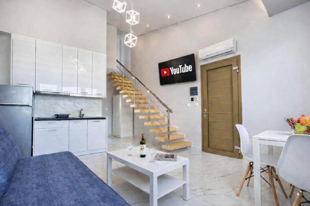 a living room with a couch and a table and a kitchen at MPL Apartments & maisonettes in Limenaria