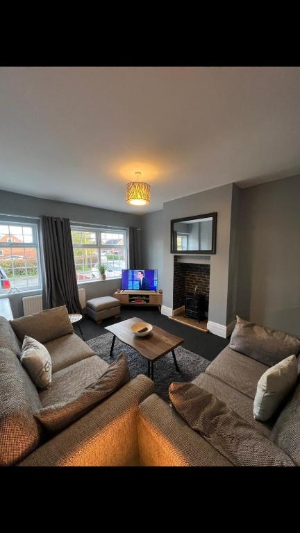 a living room with two couches and a tv at The house with a view in Warrington