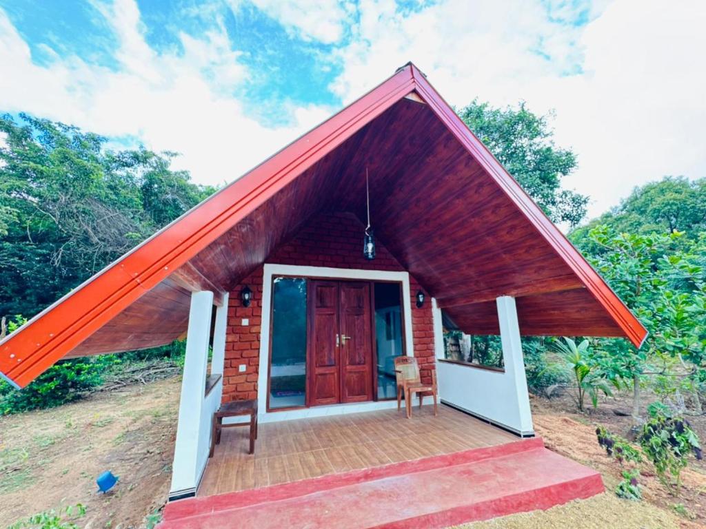 a small house with a red roof at Sigiriya Chena Villa in Sigiriya