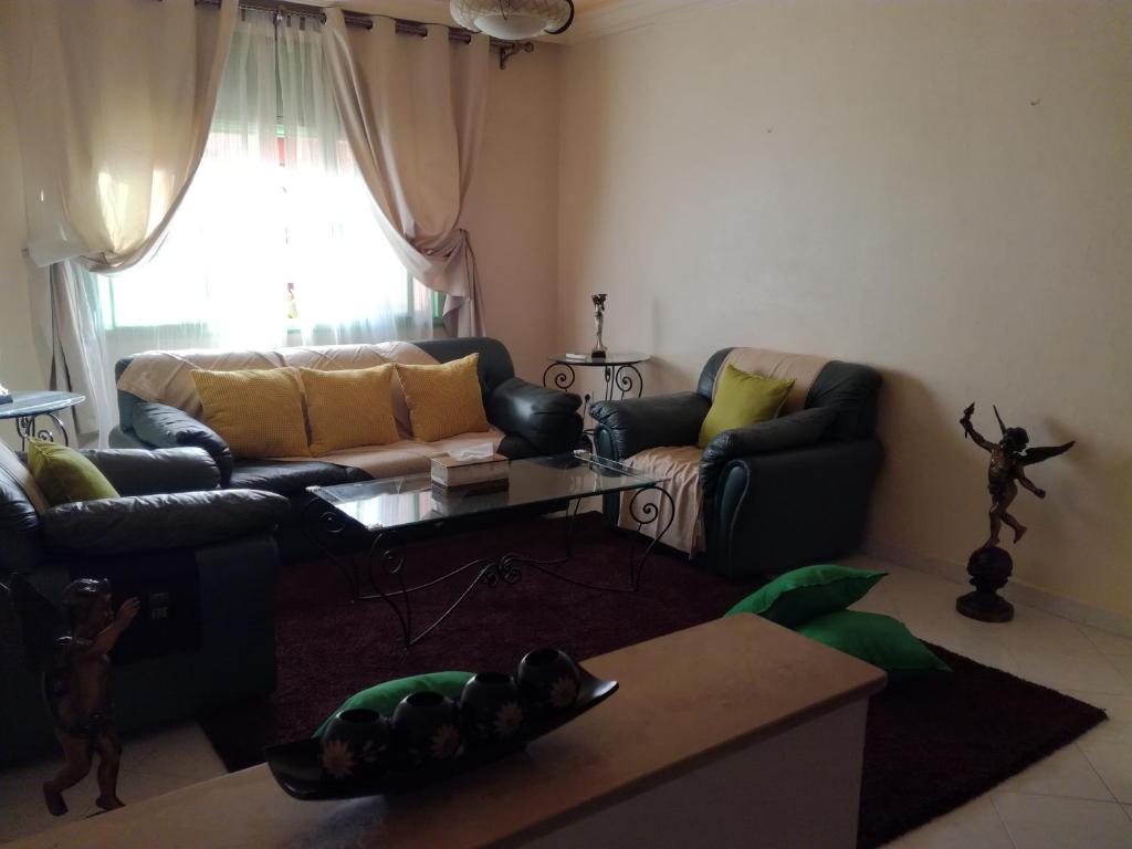 sala de estar con sofá y mesa en Kim Apartment, en Marrakech