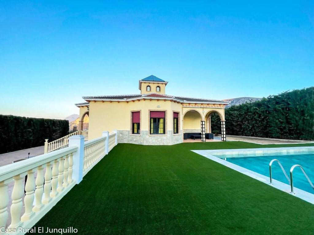 a large house with a swimming pool in the yard at Casa Rural El Junquillo in Cuevas de San Marcos
