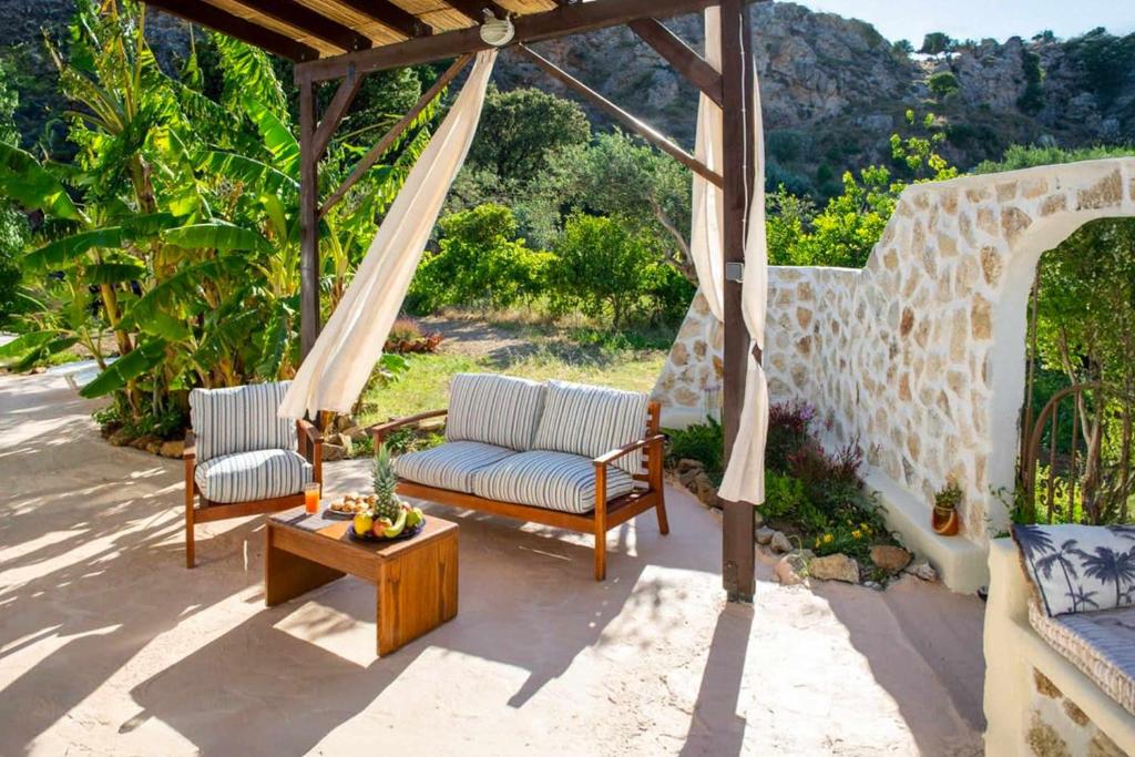 a patio with two chairs and a table at Atlantic Cave Haven-Seaside, Fully Equipped in Kolymbia